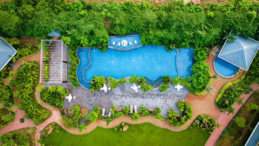 Aerial view of swimming pool surrounded by lush gardens at MAYFAIR Oasis Resort and Convention Jharsuguda