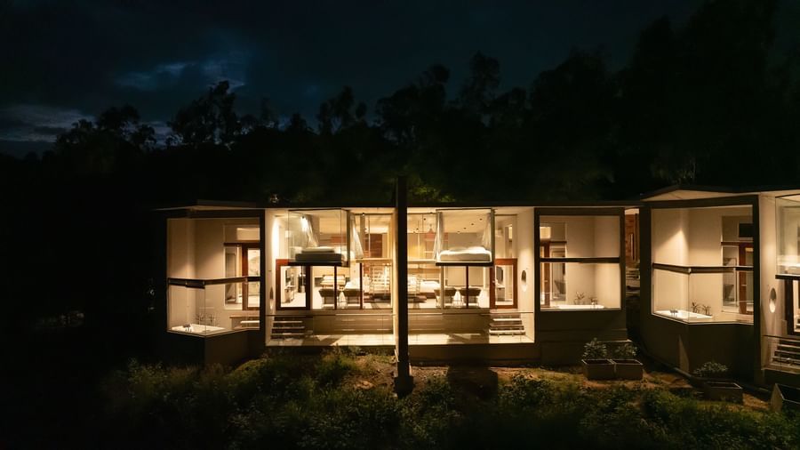 A row of modern houses illuminated at night, revealing their interior spaces and architectural design | Gaia Studio | RD's Nature Retreat, Bangalore