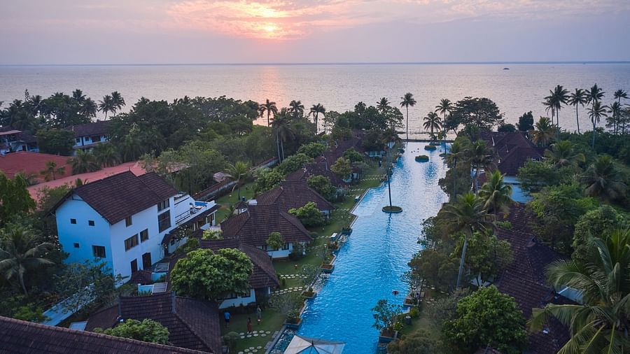 an image of an aerial view india's largest swimming pool with rooms and trees in view - Rhythm Kumarakom