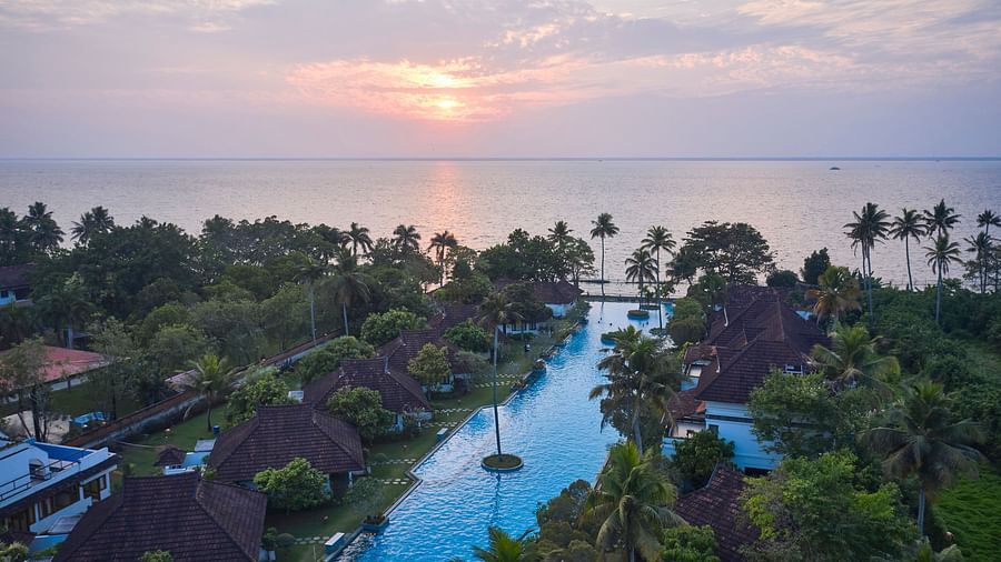 india's largest swimming pool with rooms and trees in view - Rhythm Kumarakom