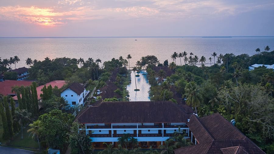 bird's eye view of india's largest swimming pool with rooms and trees in view - Rhythm Kumarakom