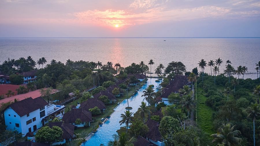 an image of bird's eye view of swimming pool with rooms and trees in view - Rhythm Kumarakom
