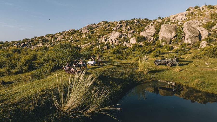 An image of a lake with the backdrop of a rocky mountain - Utsav Camp Sariska