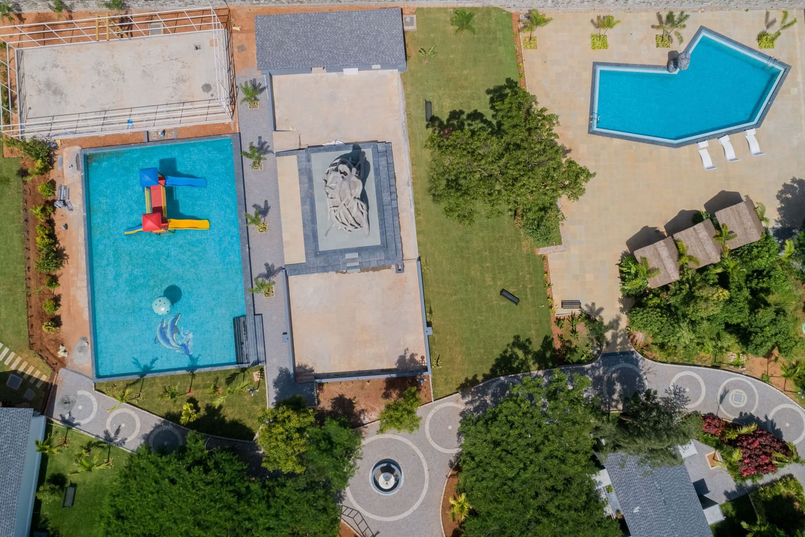 Top view of two pools at Darza Resorts in Coimbatore with trees surrounding them.