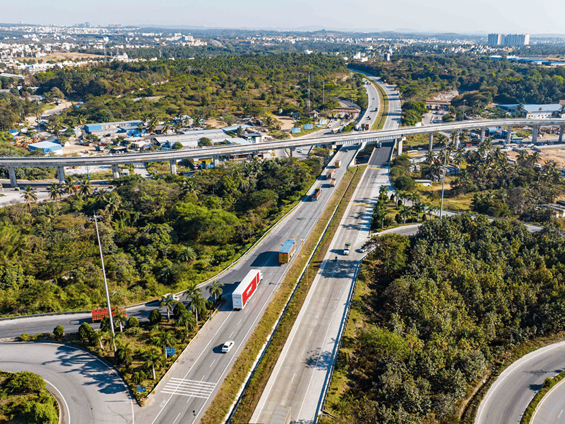 Aerial view of multiple long winding highways intersecting each other with some greenery surrounding them.