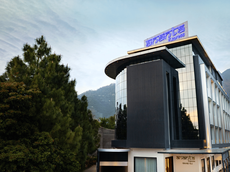 The modern multi-storey exterior of the hotel building with large glass windows during the day at Ananta Express, Katra.