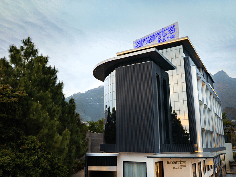 The modern multi-storey exterior of the hotel building with large glass windows during the day at Ananta Express, Katra.