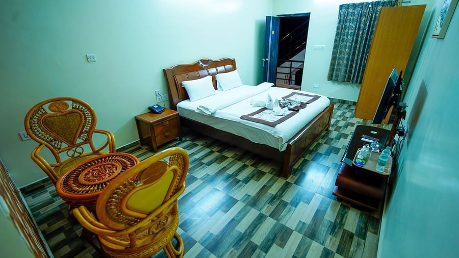 Deluxe Room of GK Hill View Resort furnished with a king size bed and sitting area for two.