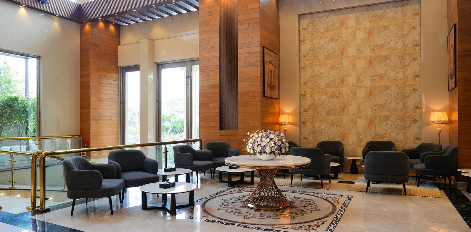 A wide view of The Meriton's sophisticated common area, featuring dark upholstered seating, round tables, and decorative wall panels, suggesting a lounge or bar.