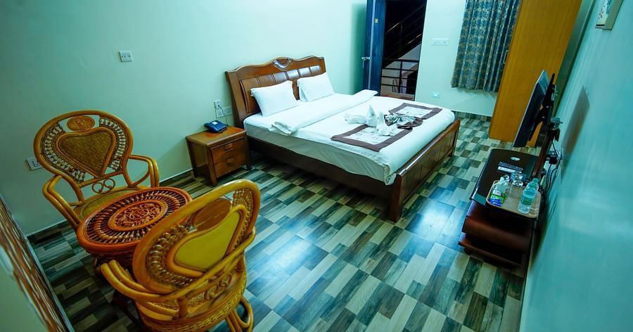 Deluxe Room of GK Hill View Resort furnished with a king size bed and sitting area for two.