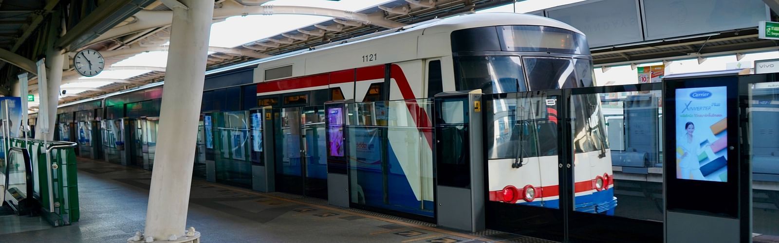 The BTS Skytrain at the terminal during daytime with a train waiting.