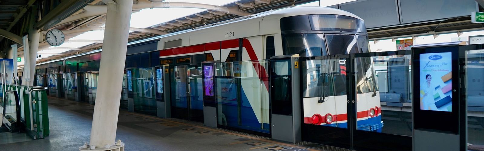 An overview of the BTS Skytrain at the terminal during daytime with a train waiting.