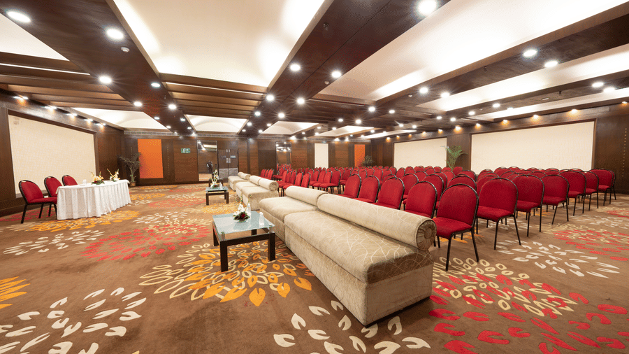 ABF09435A seminar room with rows of red chairs, a podium, and a speaker couch | HHI Varanasi