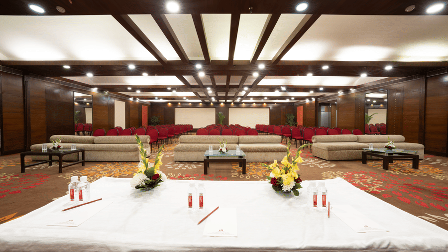 A conference hall with a main stage table and 3 couches for panellists | HHI Varanasi