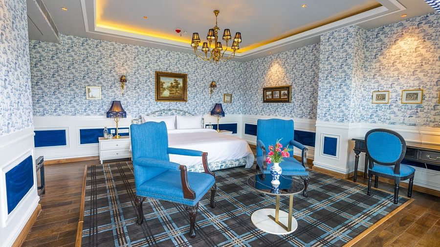 A hotel room with good decor, blue chairs and a large bed under a chandelier  - The Manor Luxury Hotel, Shimla