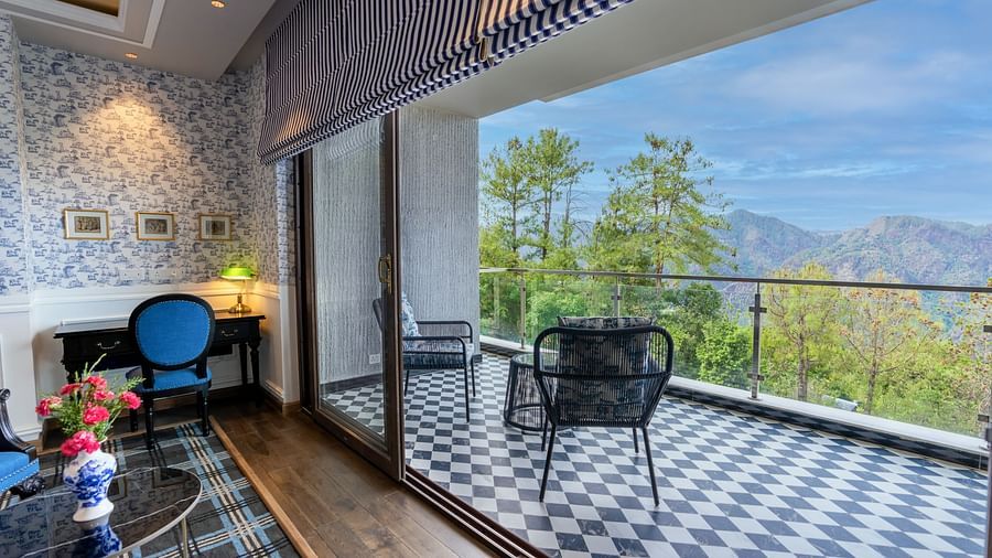 A hotel room with a chair placed in the balcony  - The Manor Luxury Hotel, Shimla