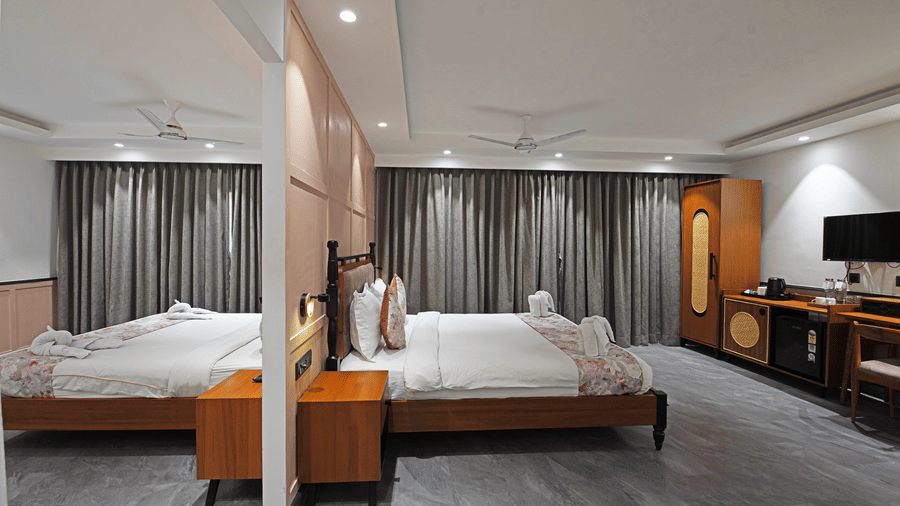 Both rooms in a Suite Quad at Hotel Sonar Bangla, Kolaghat, as seen on either sides of the partition, with identical settings and a well-lit, spacious layout