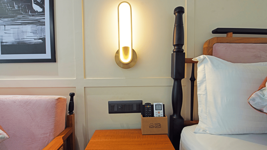 Close up of corners of the double bed and the cushioned wooden sofa in the Superior Deluxe Room at Hotel Sonar Bangla, Kolaghat.