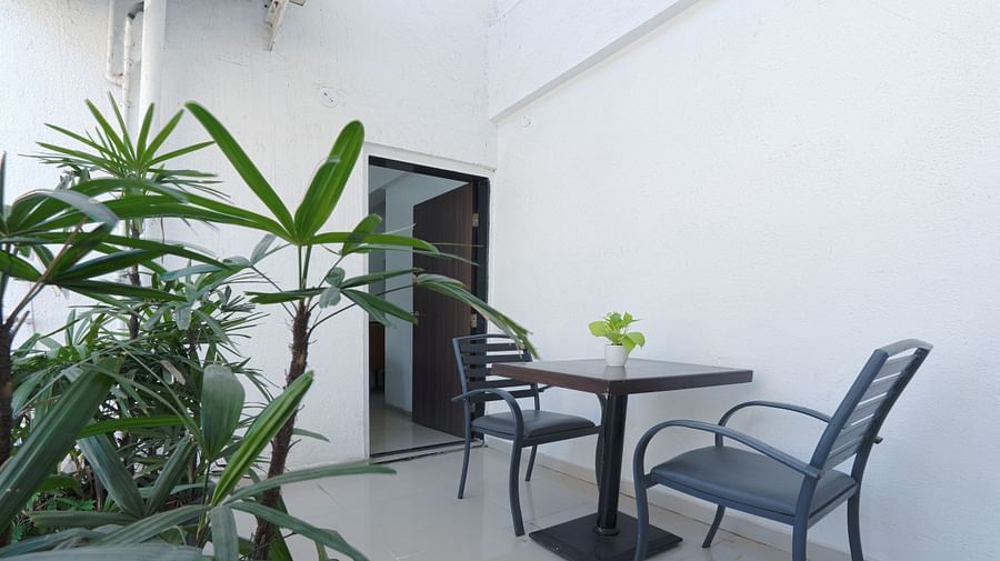 alt-text Outdoor seating area surrounded by greenery - Magnus Aerith Studio, Kharadi