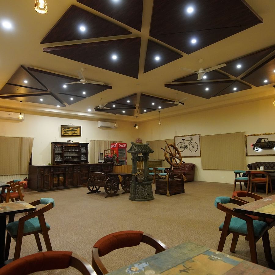 The spacious bar furnished with cart-shaped interiors and curated touches at GK Hill View Resort.