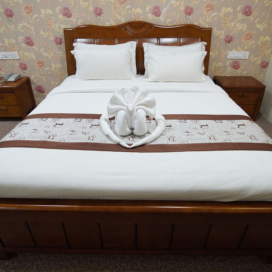 Peacock-shaped turkey towel placed on the double bed in the Themed Villa that also features a wall-mounted AC.