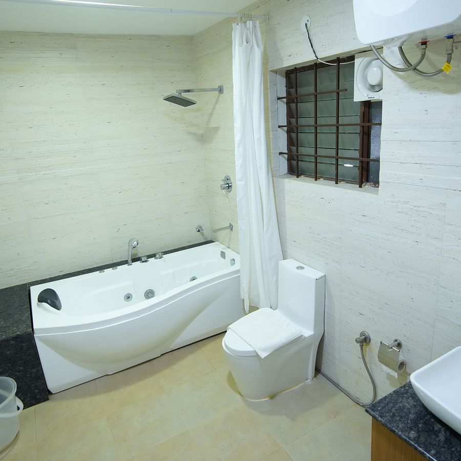 The bathroom of the Themed Villa is furnished with a Jacuzzi, sink and western commode.- GK Hill View Resort