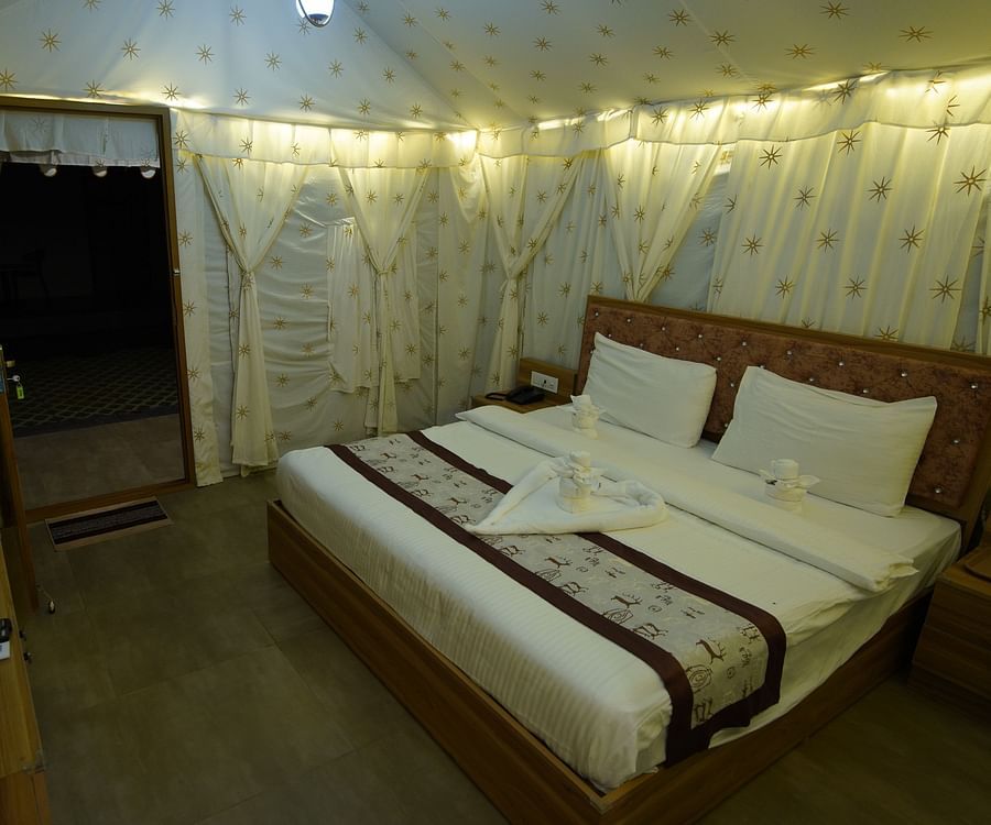 Double bed in the spacious Tent villa of GK Hill View Resort spaciously furnished with bedside tables.