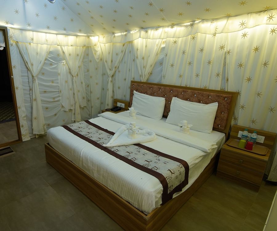 Double bed in the spacious Tent villa of GK Hill View Resort spaciously furnished with bedside tables.