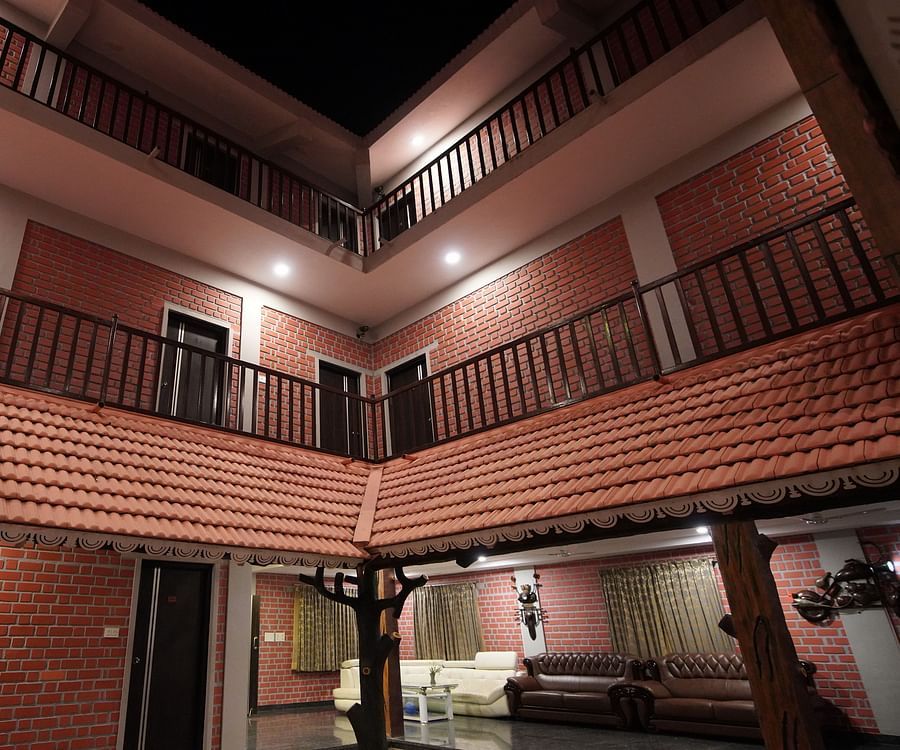 External view of a brick building in GK Hill View Resort at night with ample lighting.