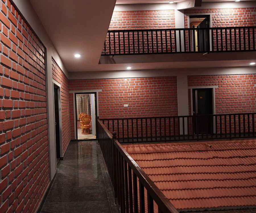 Corridor of GK Hill View Resort with built building and ample lighting.