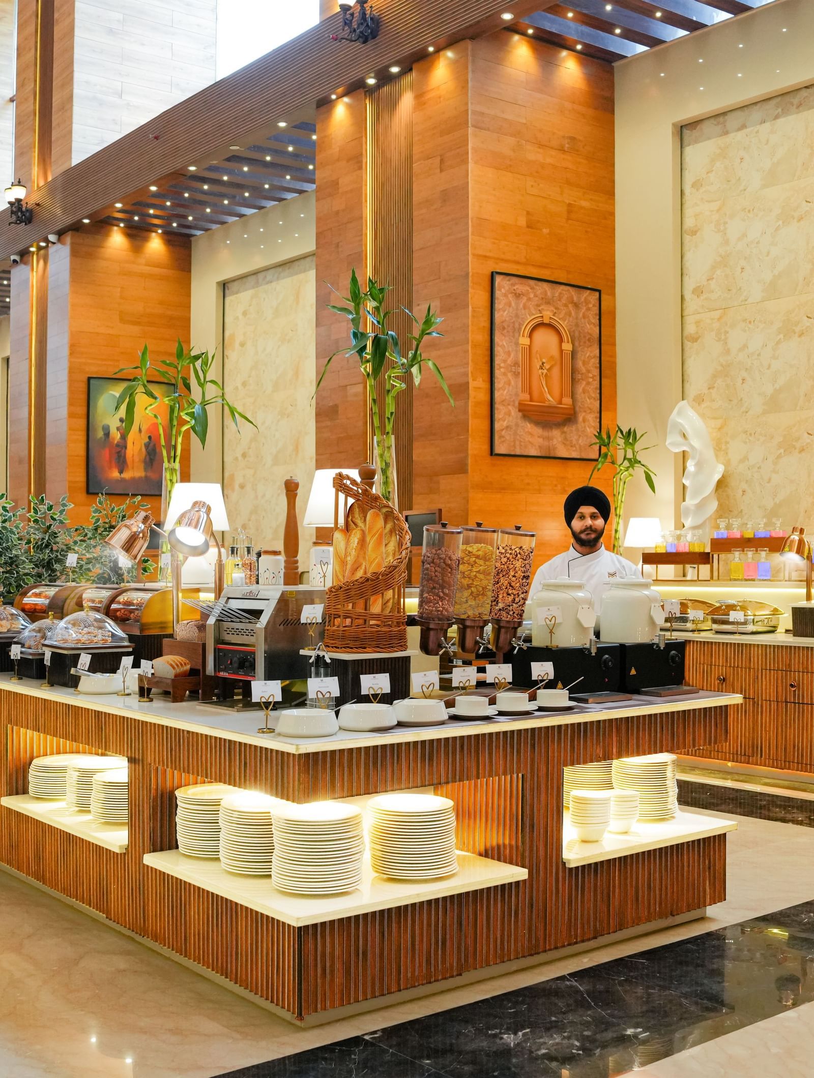 An expansive buffet counter of the Bayleaf restaurant with staff members standing around it at The Meriton.