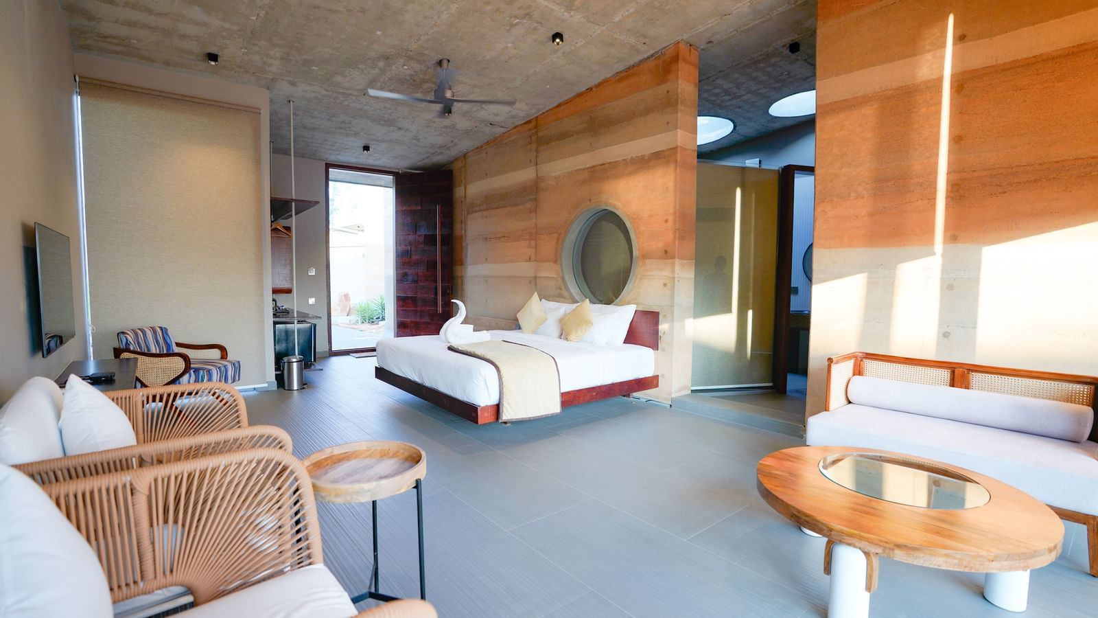 A view of the hotel room, showing a sitting area and a table with a large bed in the middle.