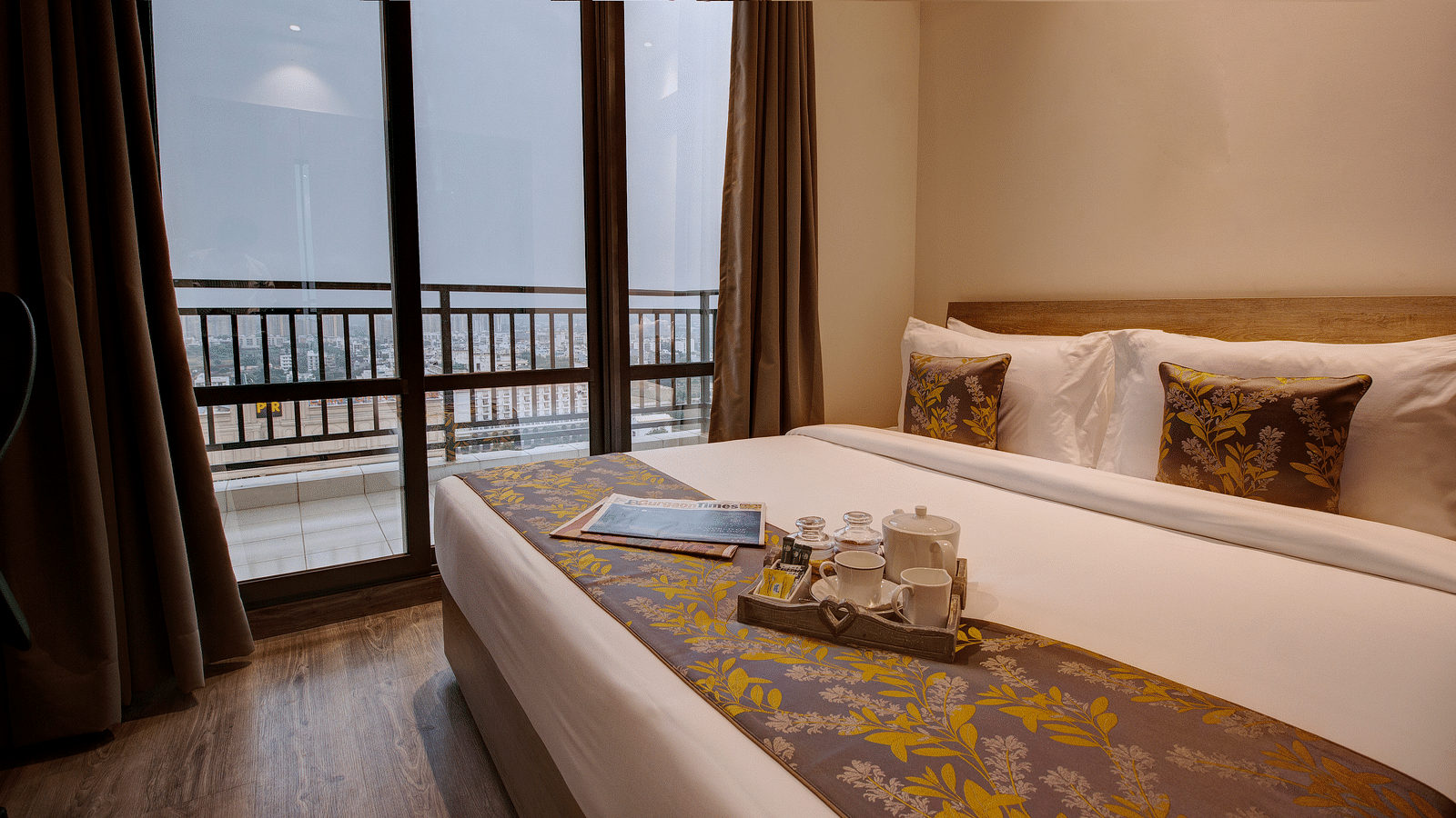 A king bed with pillows and bed runner inside the Two bedroom Executive Suite - Rhythm Gurugram