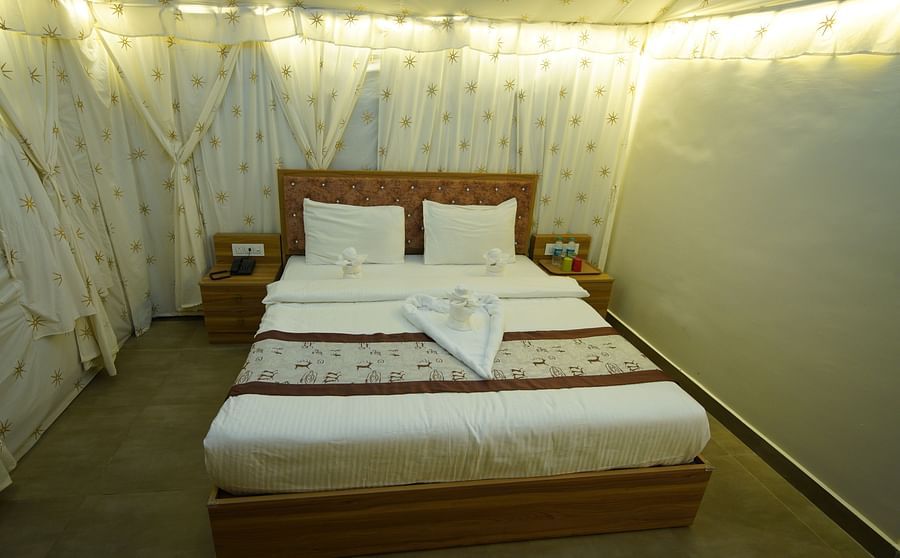 Double bed in the spacious Tent villa of GK Hill View Resort spaciously furnished with bedside tables.
