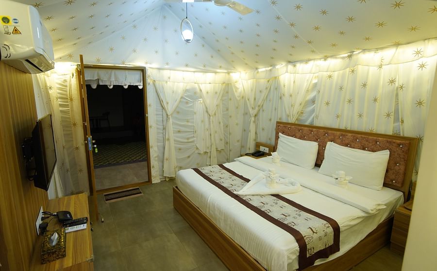 Double bed in the spacious Tent villa of GK Hill View Resort spaciously furnished with bedside tables.