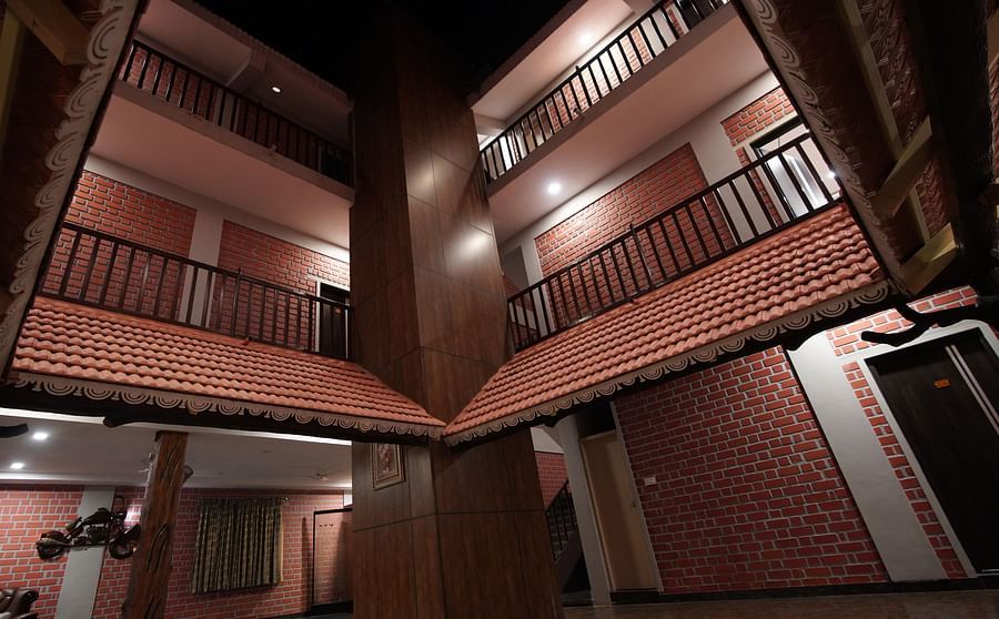 External view of a brick building in GK Hill View Resort at night with ample lighting.