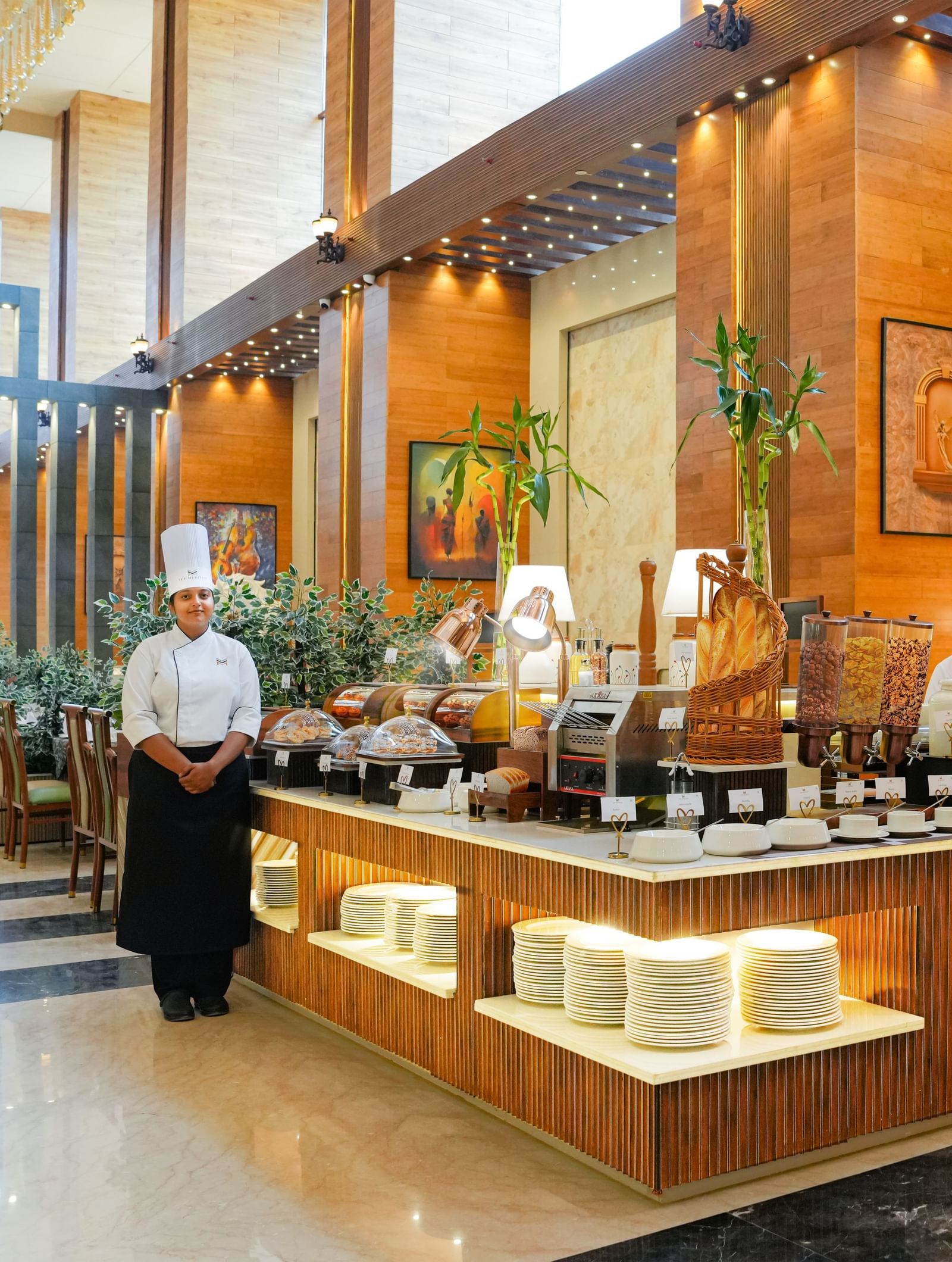 An expansive buffet counter of the Bayleaf restaurant with staff members standing around it at The Meriton.