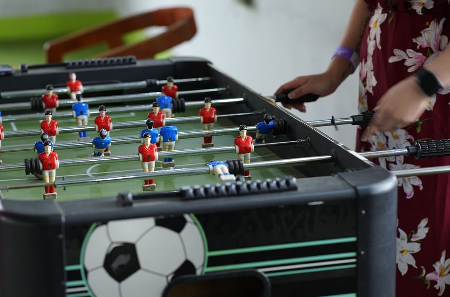 A person playing on the foosball table in the indoor games room at GK Hill View Resort.