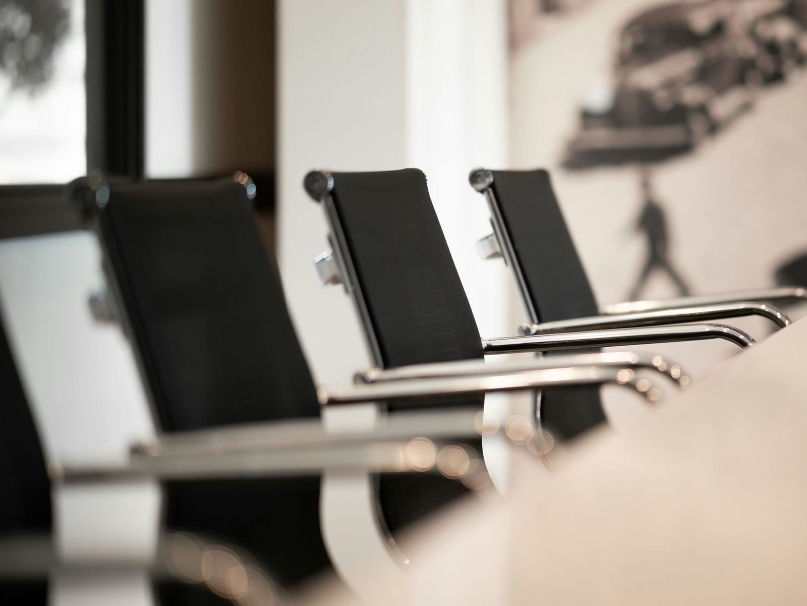 A close-up of a modern conference room with sleek chairs arranged around a table.