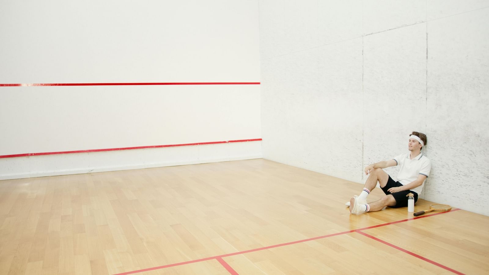 Man resting inside a squash court