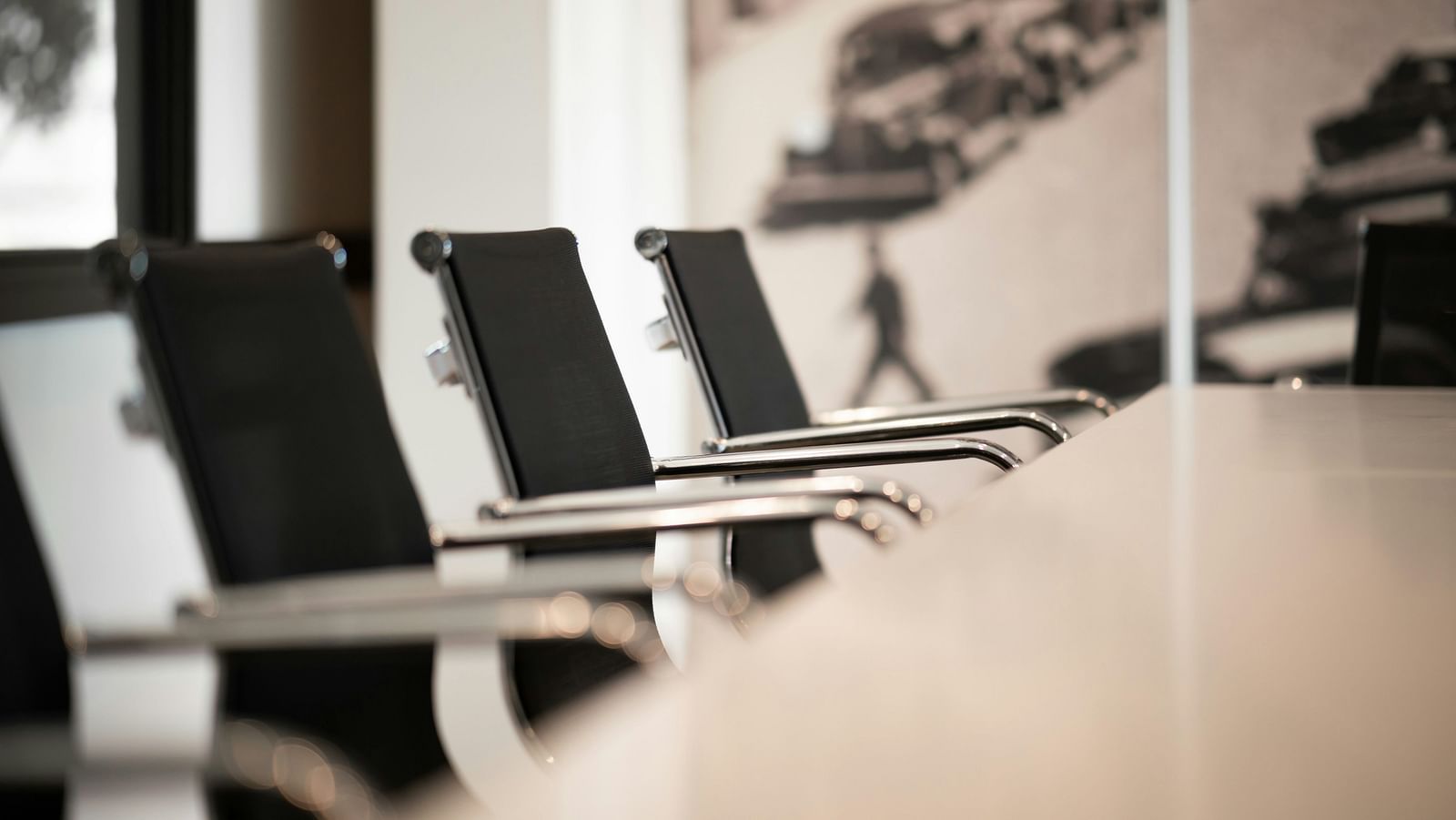 A close-up of a modern conference room with sleek chairs arranged around a table.