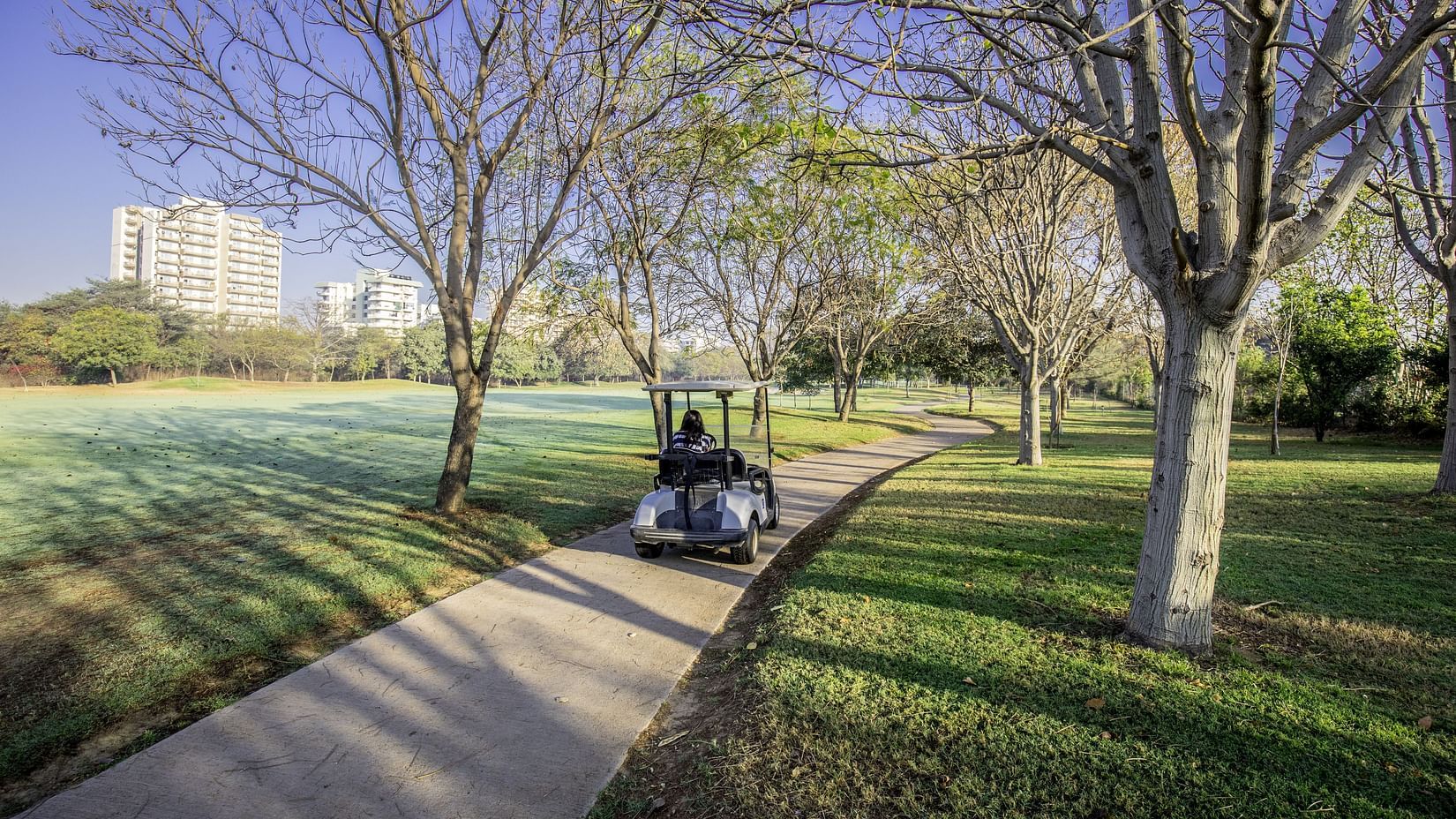 A buggy driven on the pathway next to trees - Karma Lakelands.