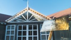 Signboard of the resort, showing the name with a decorative building entrance in the background - The Garden Ananta Elite, Rajkot