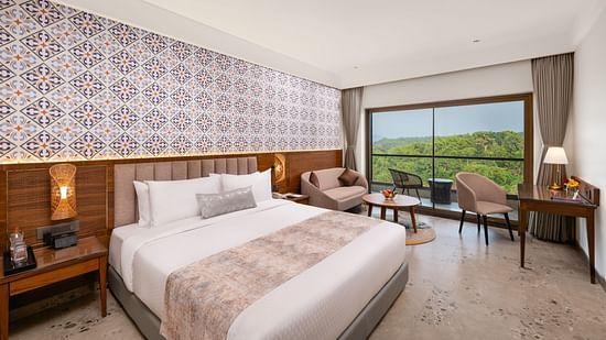 an image of a bedroom with a seating area on the balcony at Cloud9 Sarovar Premiere, Palolem Goa