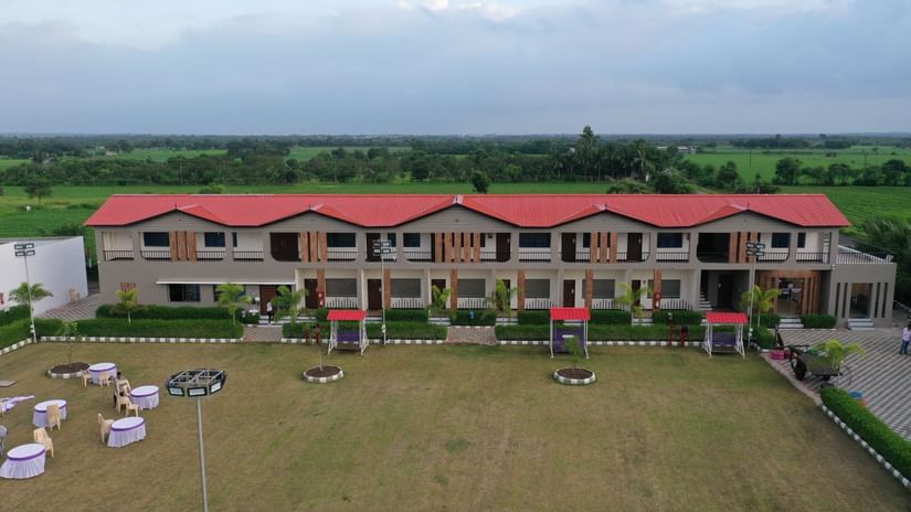 Wide drone view of VITS Select Diamond Resort, Sasan Gir showing two accommodation blocks facing the large green lawn.