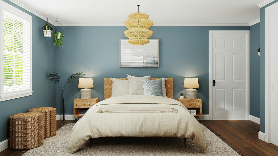 A king size bed with light bedding stands in a bedroom featuring blue walls, side tables, lamps, and 2 ottomans.