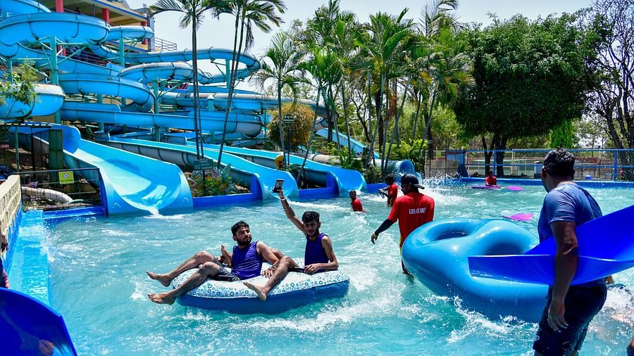 Visitors enjoying a lazy river ride with large blue tubes at a water park | Diamond Parks, Pune 