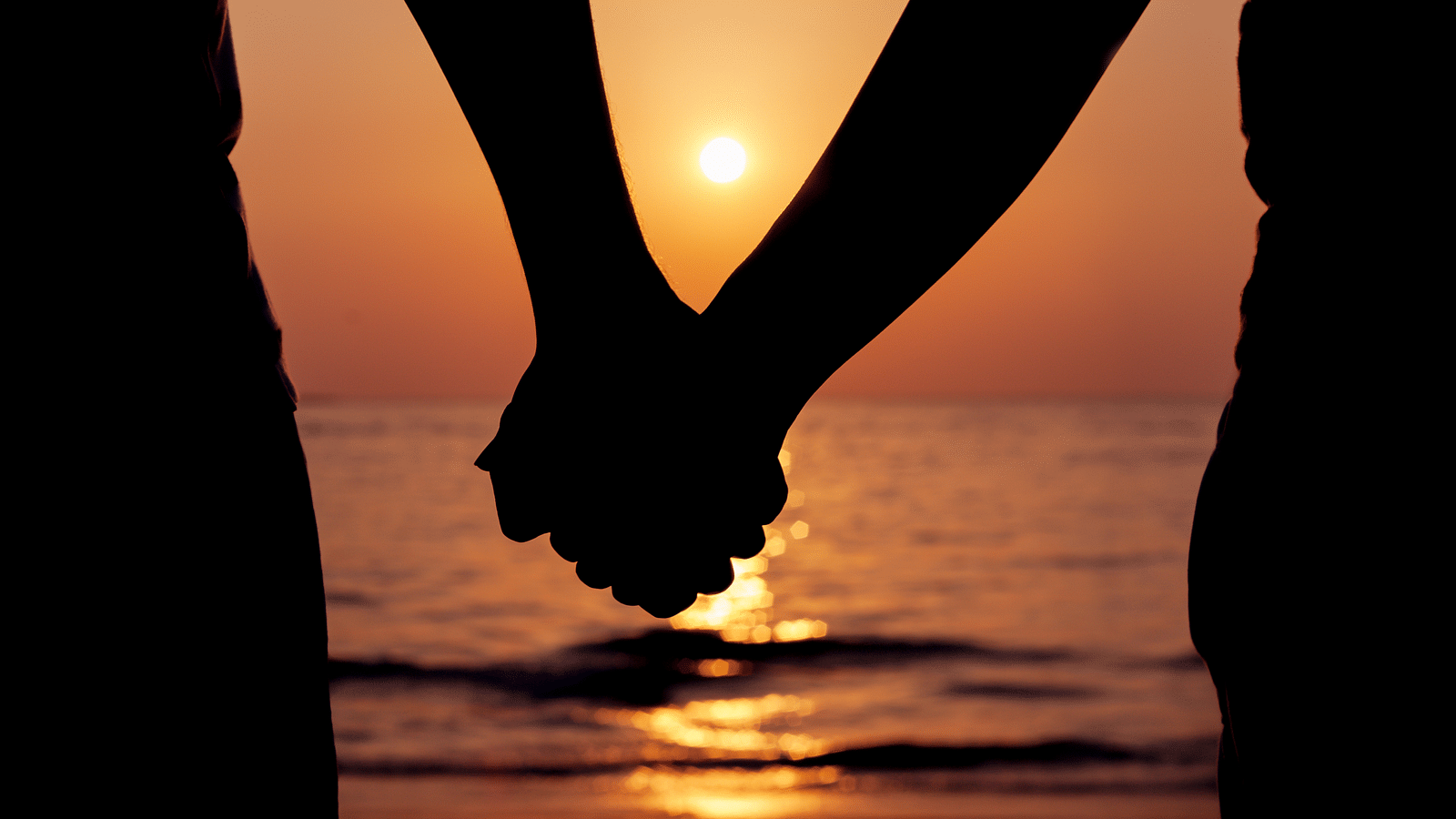 a close up shot of couple holding hands - Rhythm Kumarakom