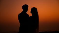 A silhouette of a couple looking at each other at sunset.