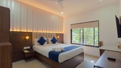 Elegant bedroom featuring a comfortable double bed and large windows- Magnus Aerith Studio, Kharadi